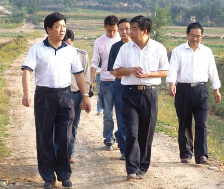 图为市委副书记,市长郭玉虎(左一)在视察礼县公路建设的情景.