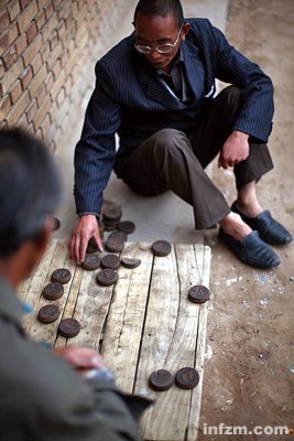 木讷的"小老头"申世红下棋打发时间.