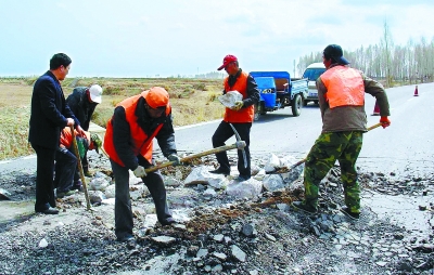 甘州区公路局施工人员正在修补乡村公路(图)-施