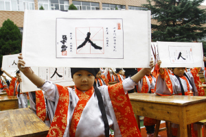 兰州七里河小学举行"开笔礼":点朱砂 写"人"字 读经典