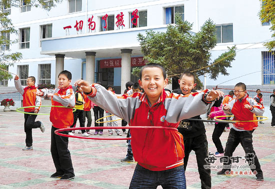 皋兰县石洞小学的孩子们在新落成的教学楼前做课间活动