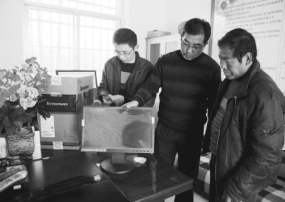 徽县县委宣传部工作人员正在为高坪村安装电脑