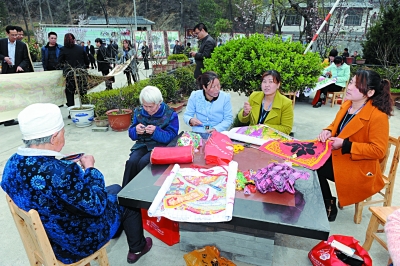 康县凤凰谷村的 绣娘 正在绣制蚕沙枕头