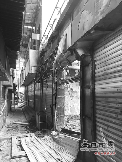 兰州西固中心市场废弃房屋起火 消防员拼接水