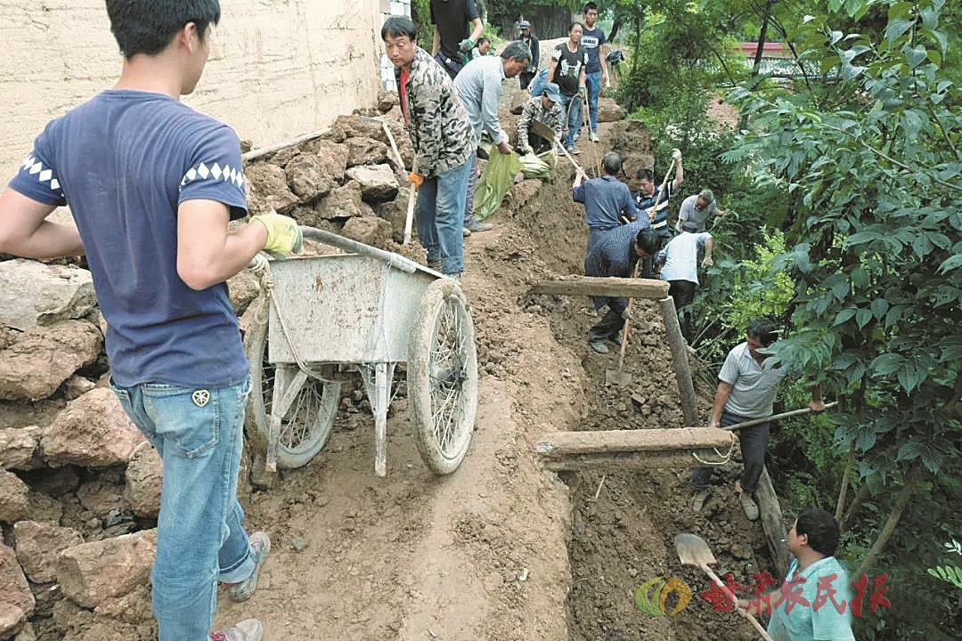 7月12日,成县小川镇新兴村村民正在抢修水毁的通村道路.