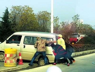 兰州一辆面包车卡在施工道路中间 众人帮忙推车