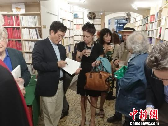 2018年6月在巴黎举办法译诗集《疼痛》首发式上为读者签名。 受访者供图。 供图 摄 2018年6月在巴黎举办法译诗集《疼痛》首发式上为读者签名。 受访者供图。 供图 摄