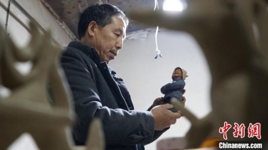 图为赵旭辉介绍他的泥塑作品。 魏建军 摄 图为赵旭辉介绍他的泥塑作品。 魏建军 摄