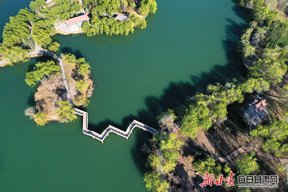 4月25日,张掖市高台县月牙湖公园绿柳似帘,湖面如镜,百米高空下俯瞰