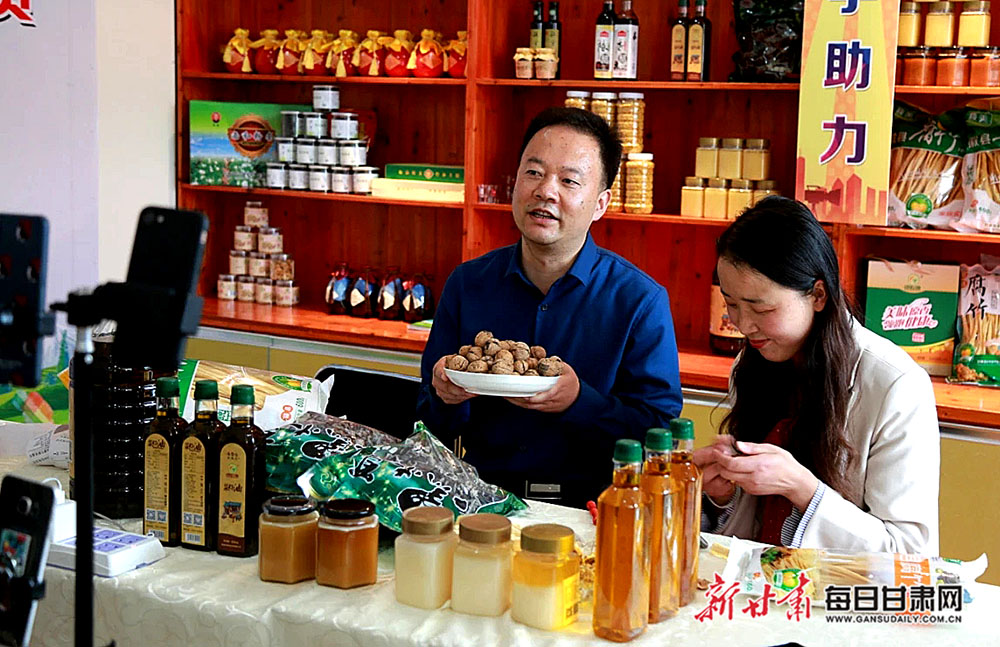 徽县县委常委,统战部部长付小龙(左)在直播间为网友推介山核桃