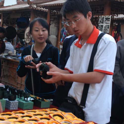 游客在敦煌工艺品街精心挑选敦煌夜光杯