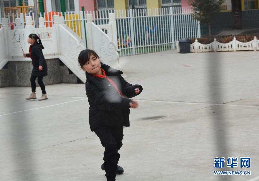 12月1日,在广河县三甲集镇火炬小学的操场上,马梅在课间和同学打羽毛