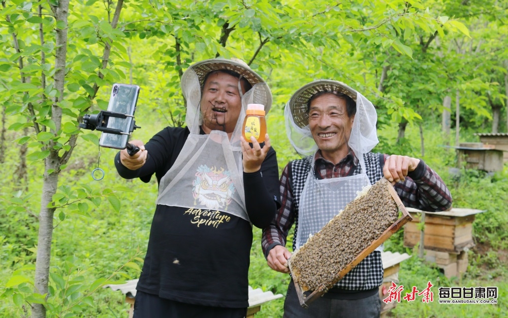 甘肃陇南市"网红达人"于志刚(左一)正和蜂农在两当县杨店镇陈家沟村