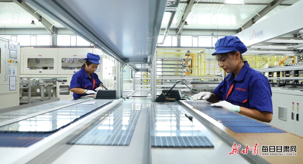 工人们正在甘肃大民新材料有限公司是800兆瓦高效光伏组件生产车间生产光伏板。王晓泾摄.JPG